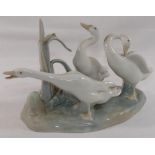 A Lomonosov USSR porcelain giraffe in seated position, 26cm long, and a Lladro porcelain geese