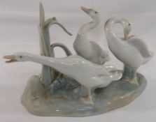 A Lomonosov USSR porcelain giraffe in seated position, 26cm long, and a Lladro porcelain geese