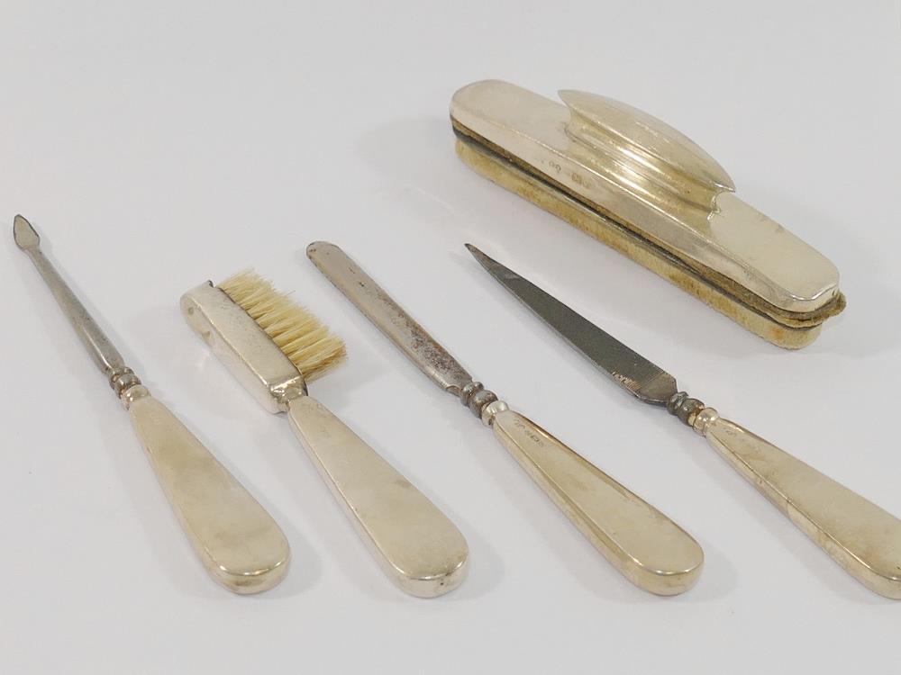 A silver handled five-piece manicure set including a nail buffer, and brush, Birmingham