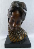 A head study of an African lady wearing a scarf, bronze with gilt detail, on rectangular plinth,