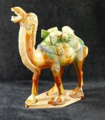 A 20th century Chinese Tang dynasty style glazed pottery figure of a caparisoned camel, on lozenge-