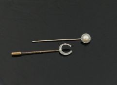 Two early 20th century stick pins, topped with a diamond set horseshoe, and a half pearl and diamond