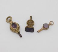 A collection of seven 19th century pocket watch keys including two gold plated stone set