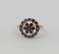A 19th century garnet circular cluster ring, the stones in closed back silver setting, in a