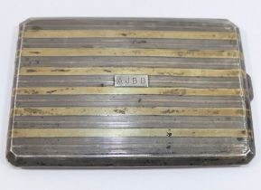 A rectangular silver cigarette case, Birmingham 1922, the lid inlaid with yellow metal bands, 12cm x