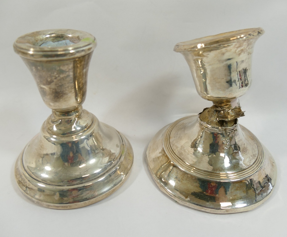 Two squat silver candlesticks, with loaded bases, both at fault CONDITION REPORTS & PAYMENT