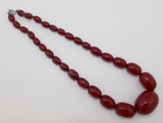A string of faturan cherry amber beads, the largest oval bead 2.1cm x 2.8cm, 42.5cm long, 38.3g