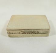 A rectangular silver pill box with gilt interior, engine turned decoration and ornate cast thumb