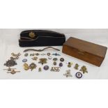A collection of enamel badges, military cap badges, Scouting items, a silver and enamel RAF