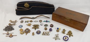 A collection of enamel badges, military cap badges, Scouting items, a silver and enamel RAF