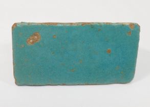 A small rectangular turquoise glazed pottery tile, possibly 12th century Kashan, Iran, 9.2cm x 4.7cm