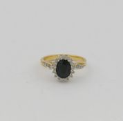 A sapphire and diamond oval cluster ring, the oval mixed cut sapphire claw set within 16 small round