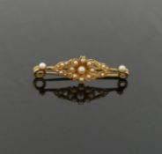 A Victorian half pearl set bar brooch, with central flowerhead design, 4.1cm long, unmarked, 3.8g
