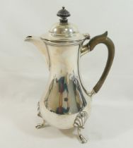 A George V silver hot water jug, Sheffield 1910, with ebonised handle and knop, of baluster form,