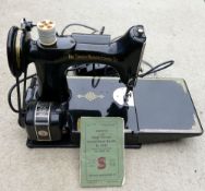 A portable Singer sewing machine, No. 221K1, with case, instruction booklet, attachments and spare