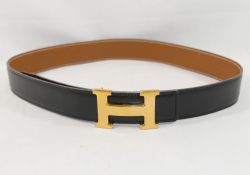 A Hermes black leather belt with gilt metal buckle, the belt 90cm long x 3.2cm wide, the buckle