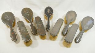 A George V silver and tortoiseshell backed four-piece hairbrush set, and one other similar