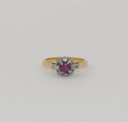 A ruby and diamond cluster ring, the round mixed cut ruby set within small baguette and round