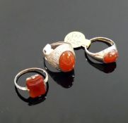 A selection of carnelian jewellery comprised of three rings, two pairs of earrings, two pendants and