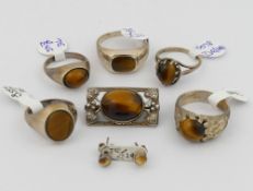 A selection of tiger's eye jewellery comprised of a string of pebble beads, a pebble bead and mother