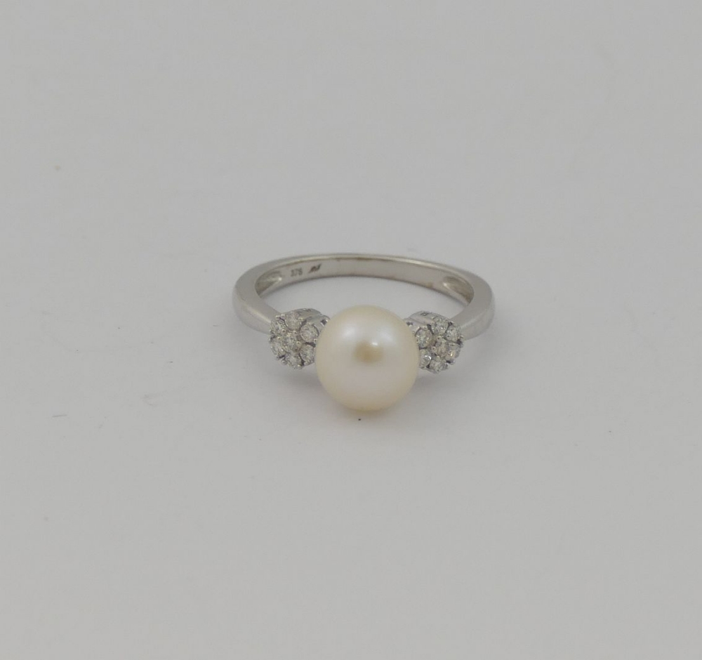 A cultured pearl and diamond ring, the central white pearl 8.15mm circumference, flanked on either - Image 2 of 3