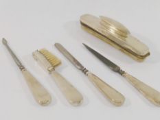 A silver handled five-piece manicure set including a nail buffer, and brush, Birmingham 1949