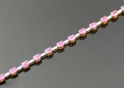 A pink sapphire and diamond line bracelet, the 19 oval mixed cut sapphires, combined weight 10.57