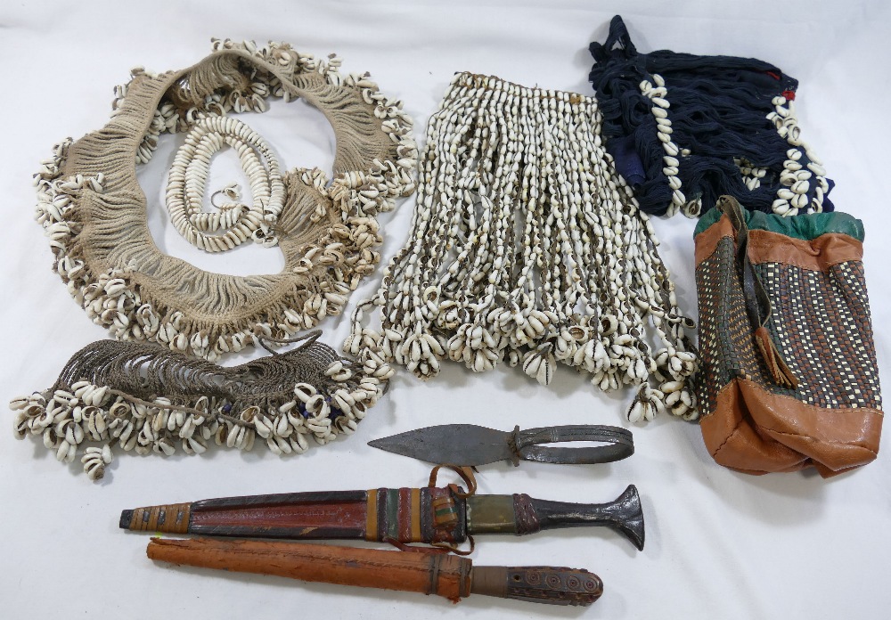 A collection of Cowrie shell decorated tribal items comprised of a headdress, shawl, belts and an