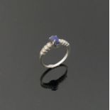 An 18 carat white gold lapis lazuli and diamond ring, the oval lapis lazuli cabochon in four claw