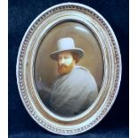 A late 19th century Continental oval porcelain plaque painted with a man wearing a grey cloak and