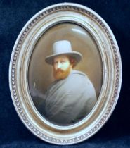 A late 19th century Continental oval porcelain plaque painted with a man wearing a grey cloak and