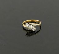 A diamond three-stone cross over ring, the round brilliant cut stones combined weight