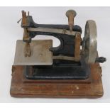 An early 20th century black painted cast iron child's sewing machine entitled ‘Baby’  mounted to a