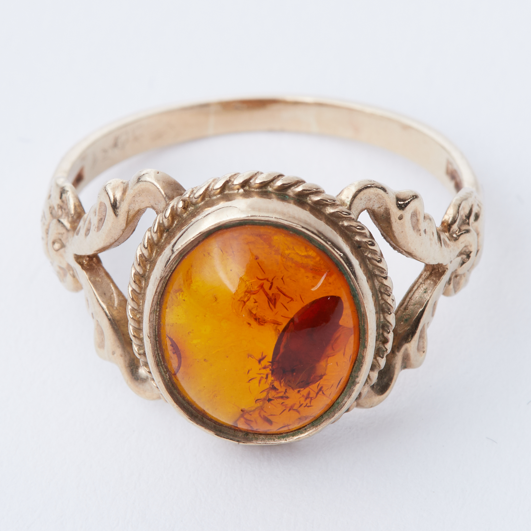 A 9ct yellow gold ornate design ring set with oval cabochon cut amber, size S 1/2 to T, 3.67gm.