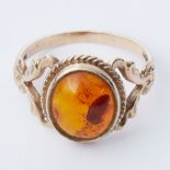 A 9ct yellow gold ornate design ring set with oval cabochon cut amber, size S 1/2 to T, 3.67gm.