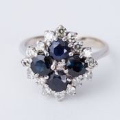 An 18ct white gold cluster style ring set with four round cut sapphires, total sapphire