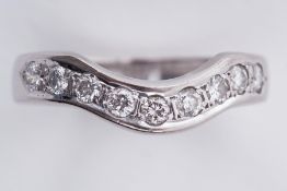 An 18ct white gold curved wishbone design ring set with nine round brilliant cut diamonds, total