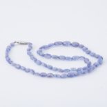 An 18" string of oval cut tanzanite beads strung to a 9ct white gold clasp, 16.70gm.
