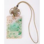A rectangular carved jade pendant, measuring approx. 6.4cm x 4.4cm, with attached cord, total weight