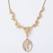 A 15ct yellow gold ornate necklace of leaf & flower design set with seed pearls with an oval pendant