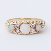 An antique 18ct yellow gold scroll design ring set with three cabochon cut opals interspaced by four