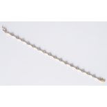 An 18ct yellow & white gold bracelet set with spaced round brilliant cut diamonds in a rub-over