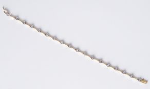 An 18ct yellow & white gold bracelet set with spaced round brilliant cut diamonds in a rub-over