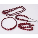 Four strands of cherry amber to include a 15.5" strand of oval shaped cherry amber,