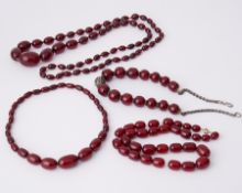 Four strands of cherry amber to include a 15.5" strand of oval shaped cherry amber,