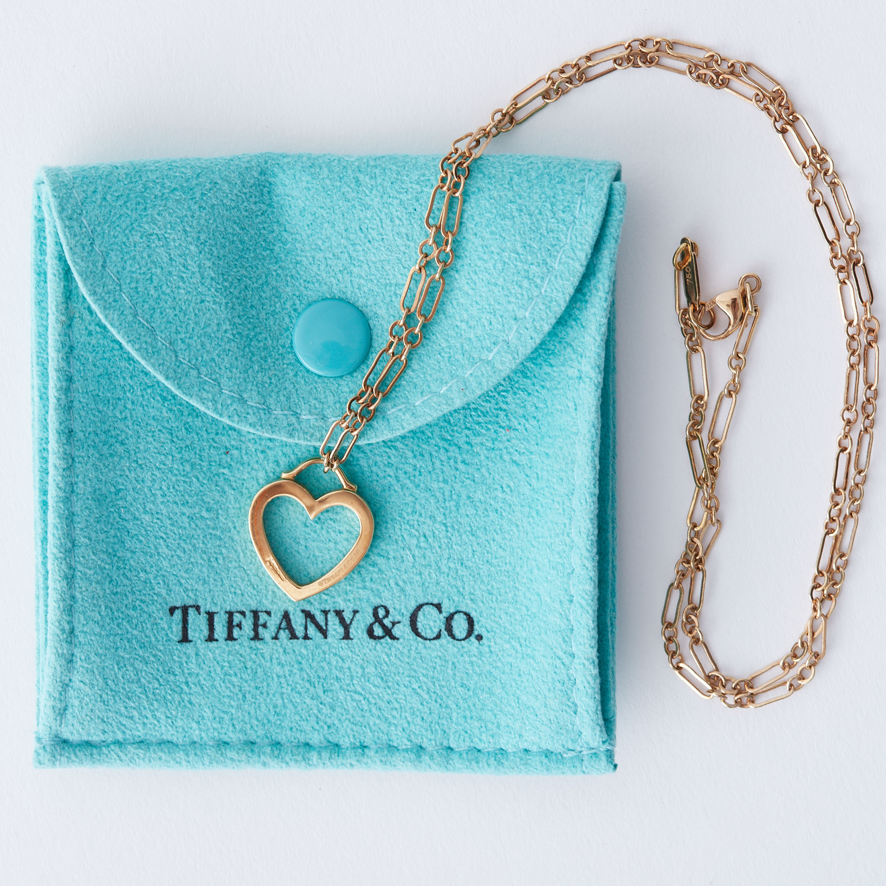 An 18ct yellow gold Tiffany open heart pendant on an 18" fancy link chain, both stamped