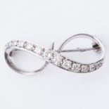 A white gold brooch in a figure of eight design, set with round brilliant cut diamonds, total