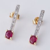 A pair of 18ct yellow gold drop earrings each set with an oval cut ruby & small round