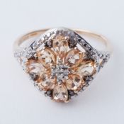 A 9ct yellow gold flower design ring set with a mixture of oval & pear shaped topaz, interspaced