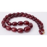 A string of oval cherry amber beads, length 28", 91.2gm.
